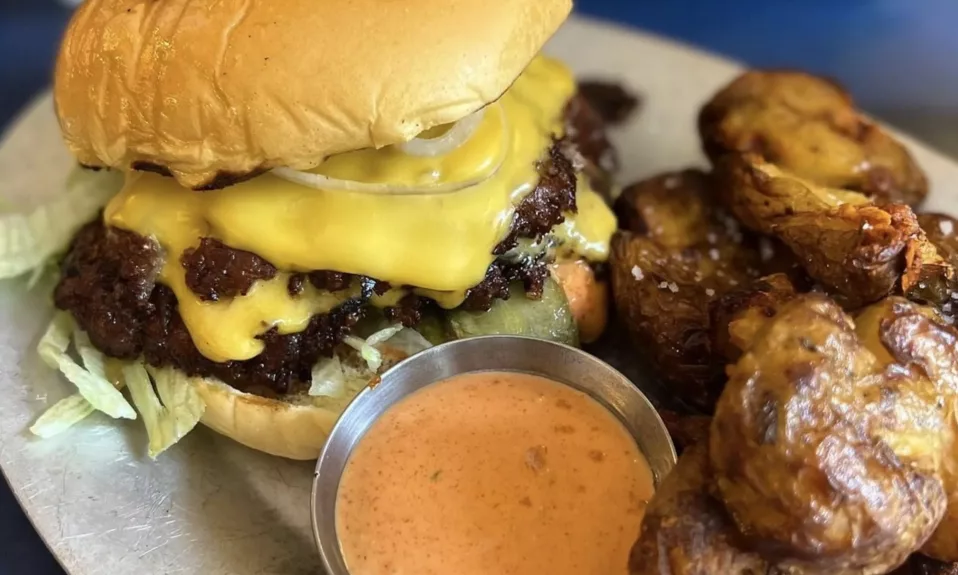 Cheeseburger avec pommes de terre et sauce.