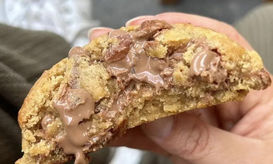 Cookie au chocolat fondant tenu à la main