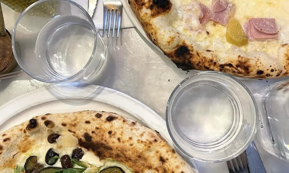 Deux pizzas avec ingrédients variés sur une table.