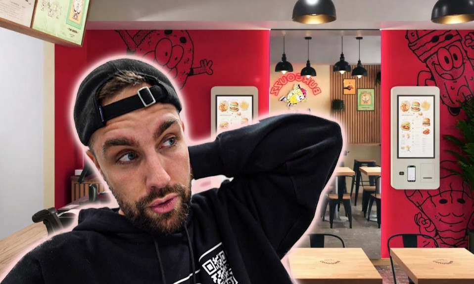 Homme dans un restaurant moderne avec bornes interactives.