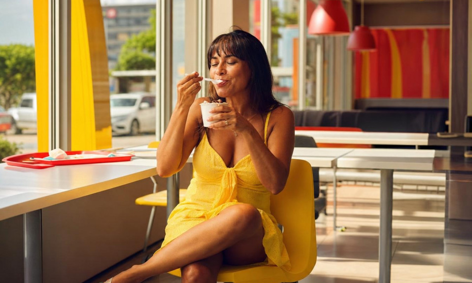 Femme en robe jaune dégustant une glace