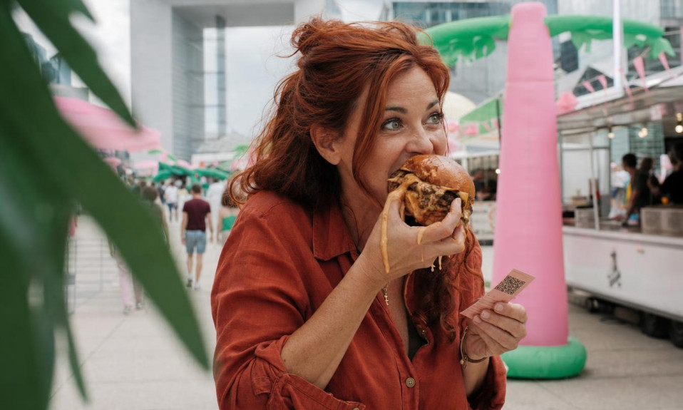 Femme mangeant un burger dans un festival urbain